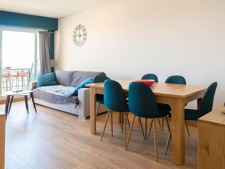 un salon avec une table, des chaises et un canapé dans l'établissement Appartement entre ciel et mer le grand large, à Hyères