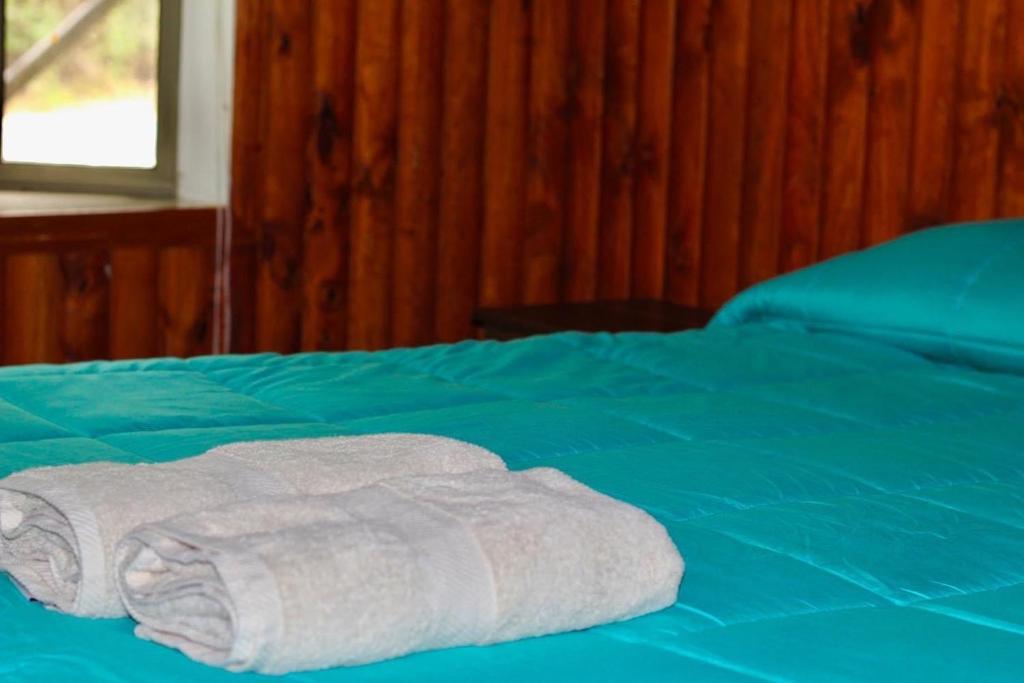 - une pile de serviettes assises au-dessus d'un lit dans l'établissement Cabañas Agua Divina, à Recinto