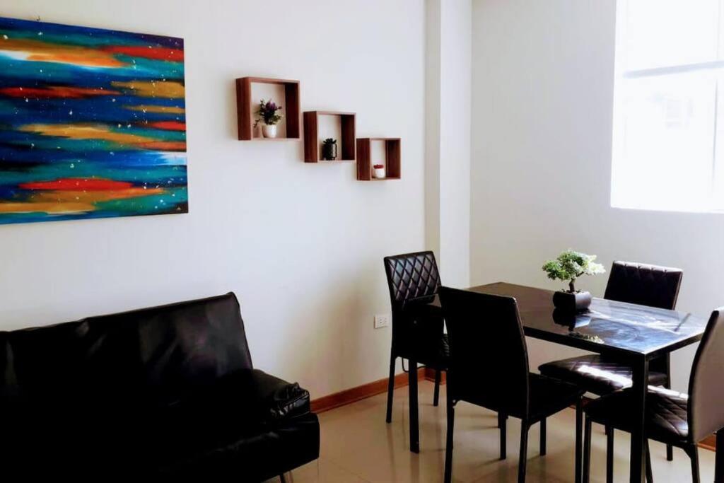 a dining room with a table and chairs and a painting at Hospedaje Libertador San Martín - Dpto. entero # 1 in Víctor Larco Herrera