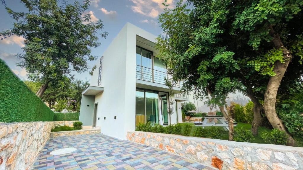 a white house with a stone walkway at Villa w Pool Jacuzzi 5 min to Marina in Antalya in Finike