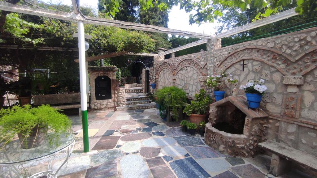 a garden with a stone wall with a stone fireplace at Los rosales in Burunchel