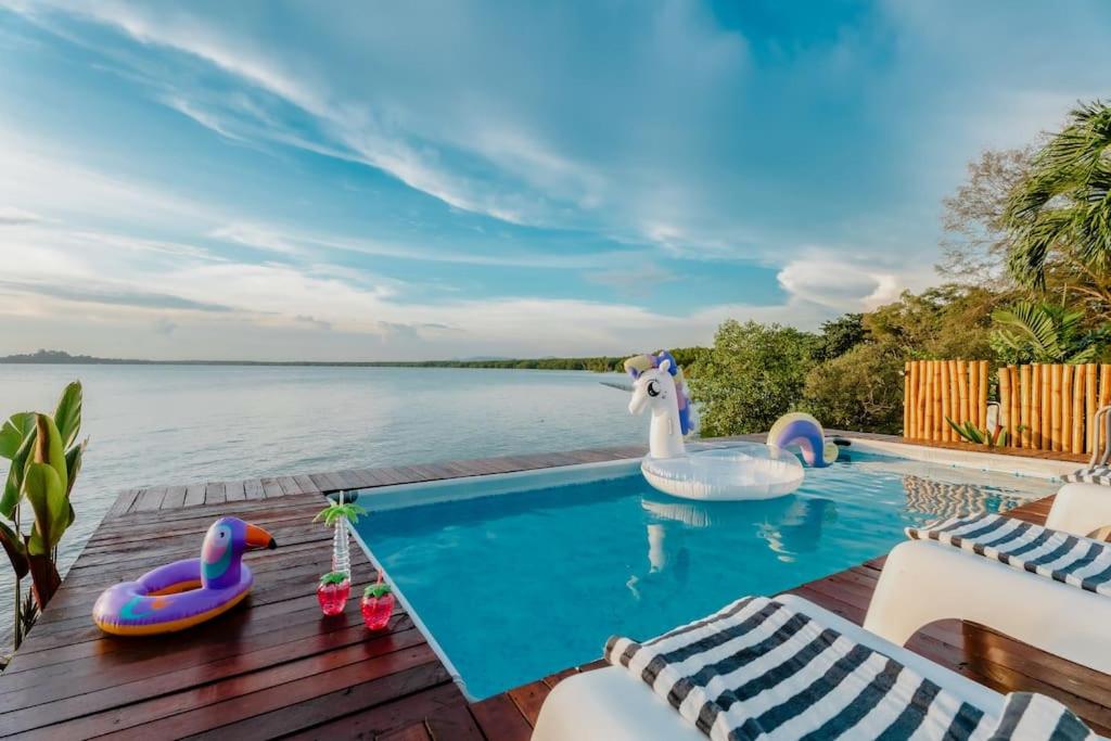 einen Pool mit Schwänen und aufblasbaren Enten auf einer Terrasse in der Unterkunft Bamboo Rimbun-Tranquil Seaside Villa, Port Dickson in Port Dickson