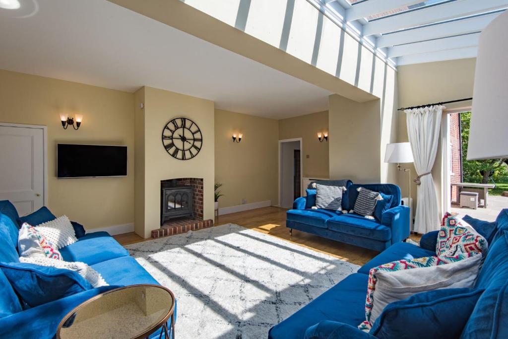 a living room with blue couches and a fireplace at The Old Post Office by Bloom Stays in Faversham