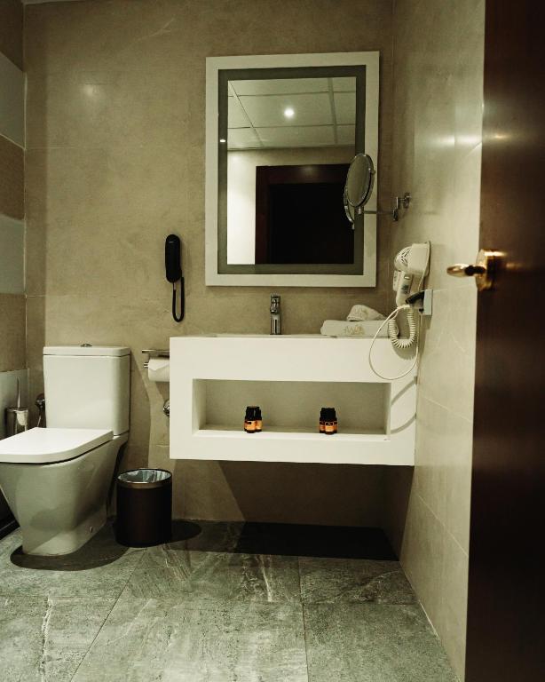 a bathroom with a toilet and a sink with a mirror at Waves Aqua Resort in Kenitra