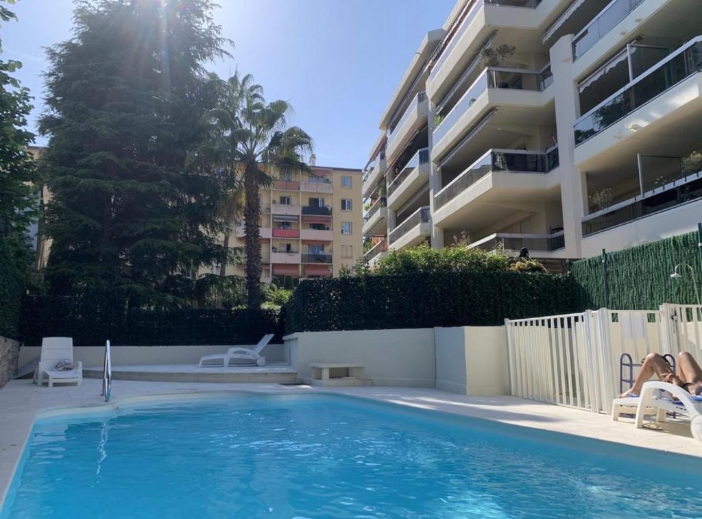 - une piscine en face d'un immeuble dans l'établissement Beau studio avec piscine, à Cannes