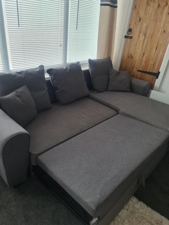 a large gray couch in a room with a window at Beautiful studio apartment in Pembrokeshire