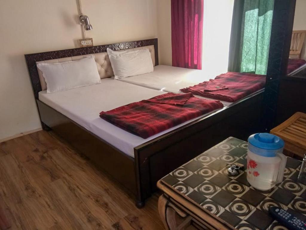 a bedroom with a large bed with a red blanket at Hotel Gyespa in Kyelang