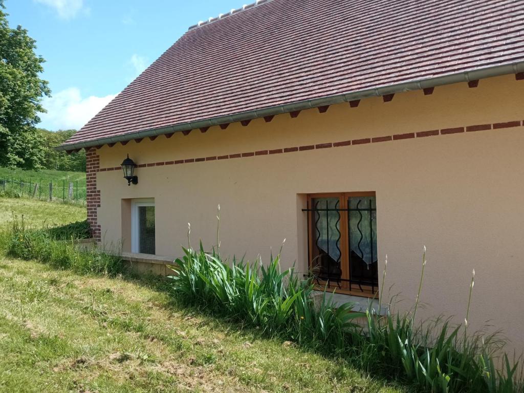 ein kleines Haus mit einer Tür und Gras in der Unterkunft la maison des taillis in Saint-Paul