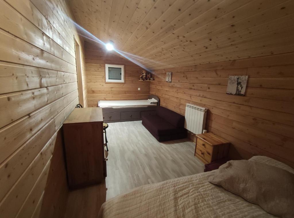 a room with a bed in a wooden cabin at Charmant chalet en Auvergne proche du lac in Saint-Rémy-sur-Durolle