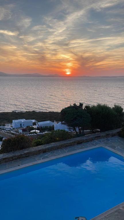 a swimming pool with a view of the ocean at sunset at Ines’s Dream in Stelida