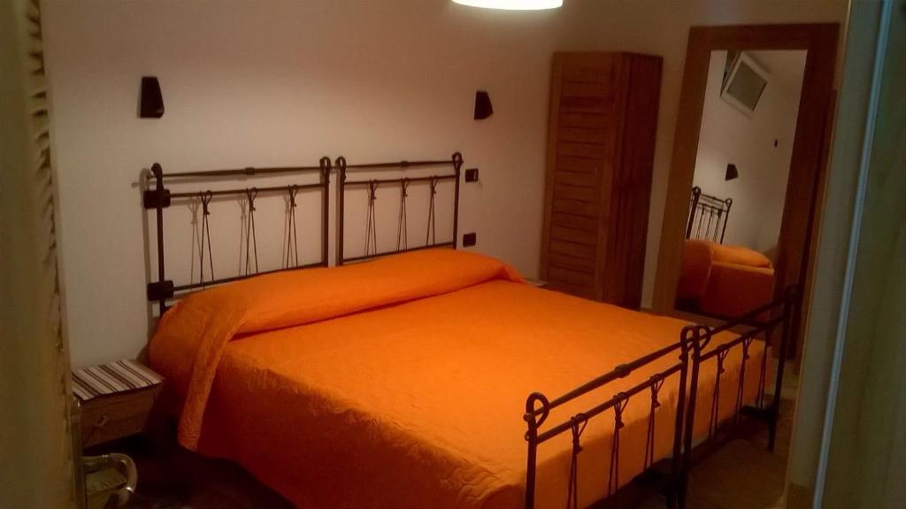 - une chambre avec un lit et une couverture orange dans l'établissement Ines’s Dream, à Stelida