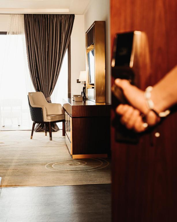 a person opening a door to a hotel room at Waves Aqua Resort in Kenitra
