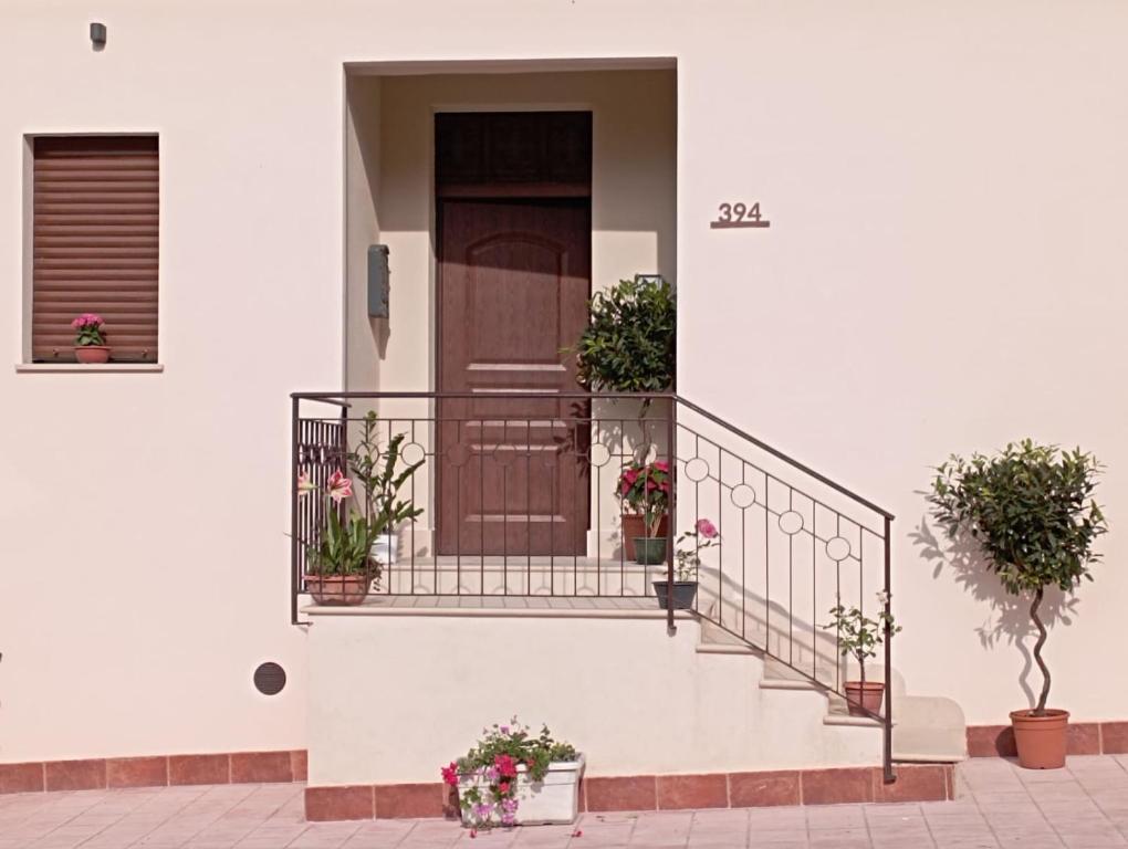 Casa Consiglio في ريالمونتي: منزل أبيض مع نباتات الفخار على الدرج