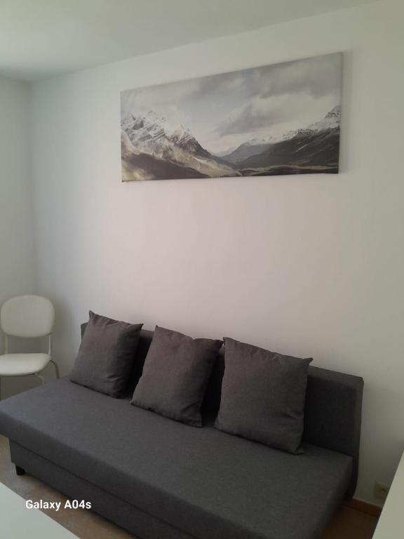a couch in a living room with a painting on the wall at 1 bedroom studio sleeps 4 in Brussels