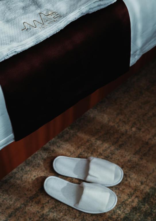 a pair of white shoes sitting on a rug next to a bed at Waves Aqua Resort in Kenitra