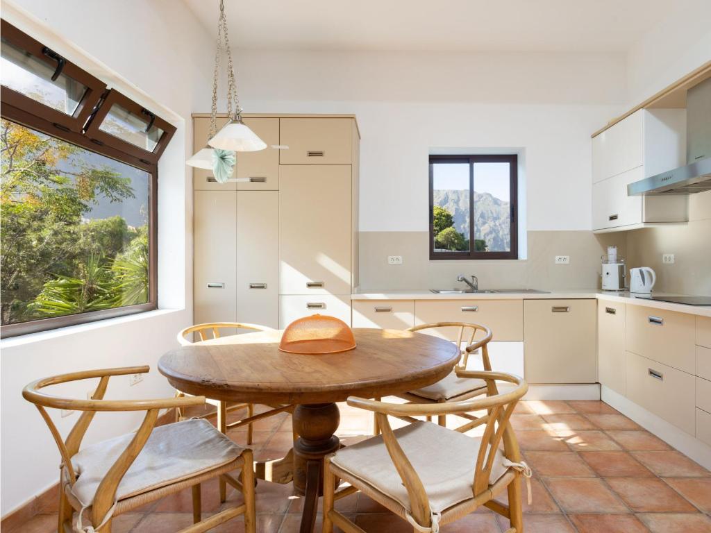 une cuisine avec une table et des chaises en bois dans l'établissement Live Buenavista del norte con terazza, à Buenavista del Norte