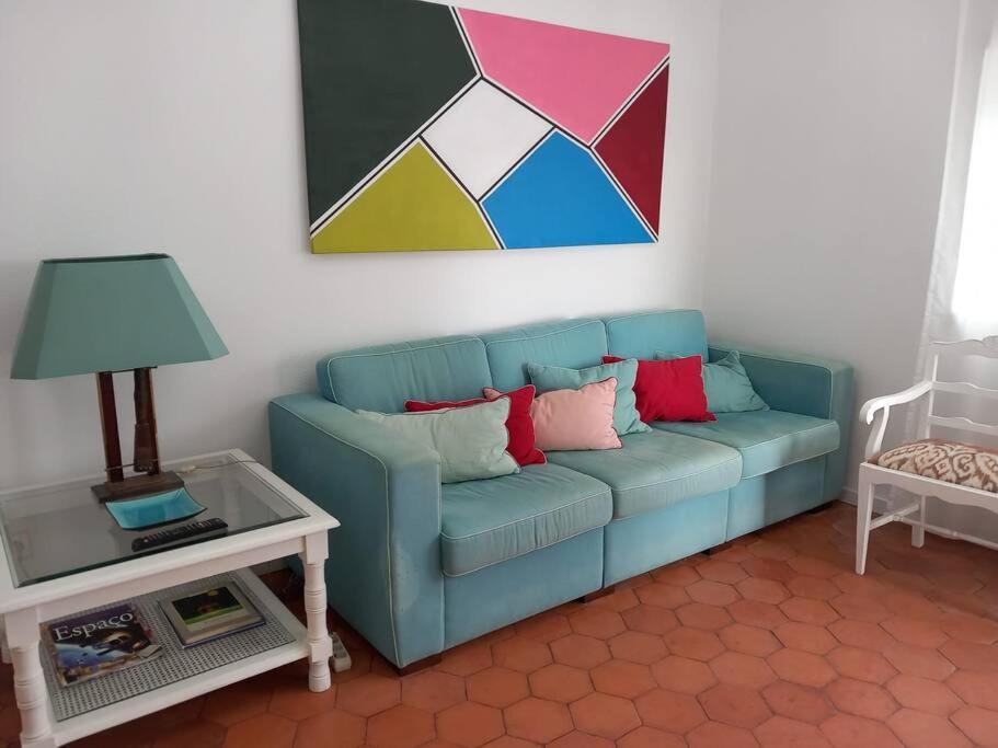een woonkamer met een blauwe bank en een tafel bij Vila Mar Apartment in Vila do Conde