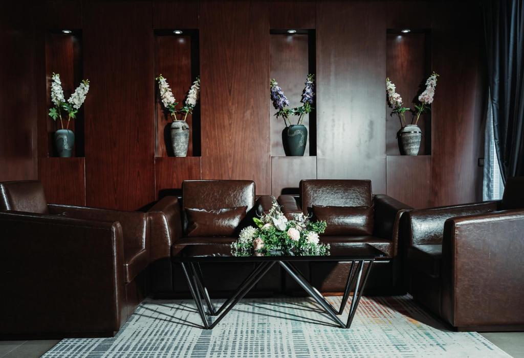 a waiting room with leather chairs and a table with flowers at Waves Aqua Resort in Kenitra