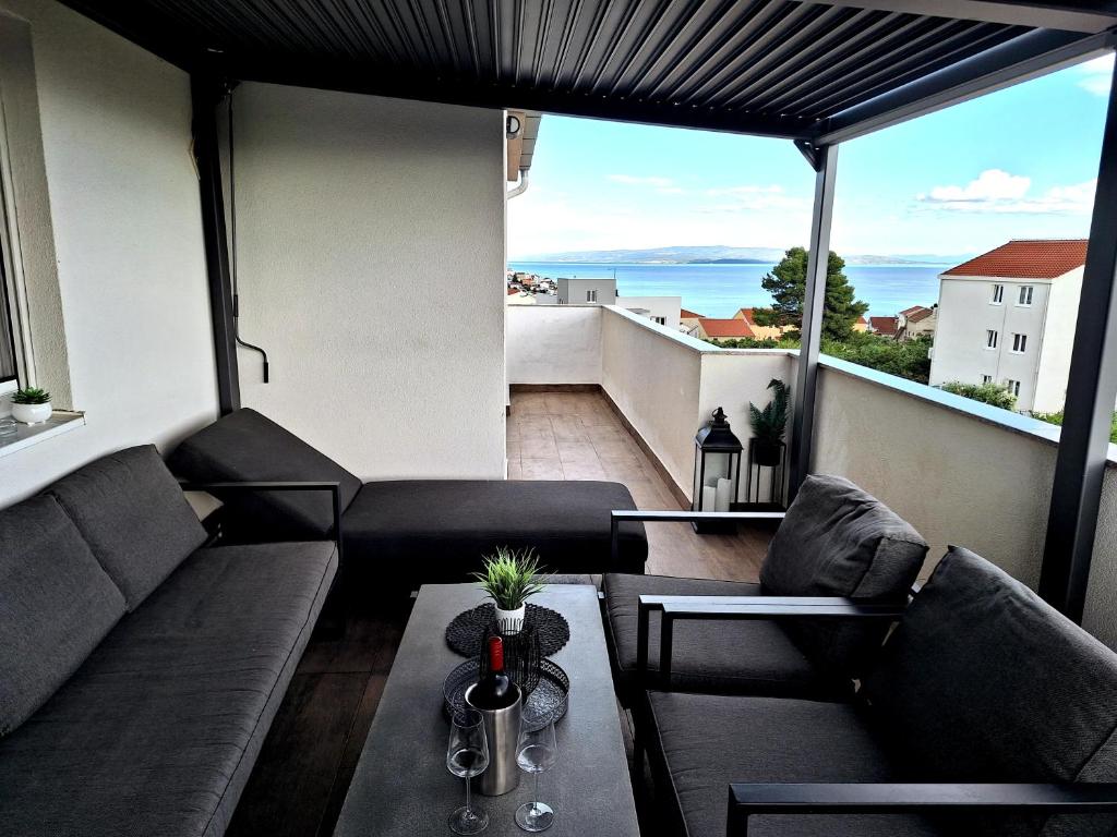 ein Wohnzimmer mit Sofas und einem Tisch auf dem Balkon in der Unterkunft Dream Variant in Trogir