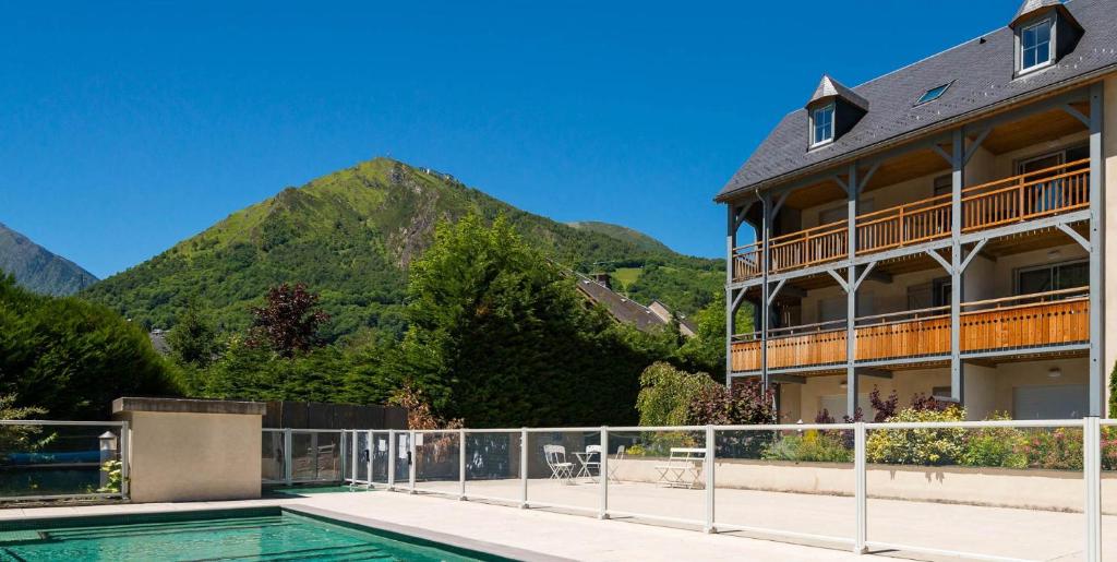 um resort com uma piscina e uma montanha em Lagrange Vacances Le Clos Saint Hilaire em Saint-Lary-Soulan