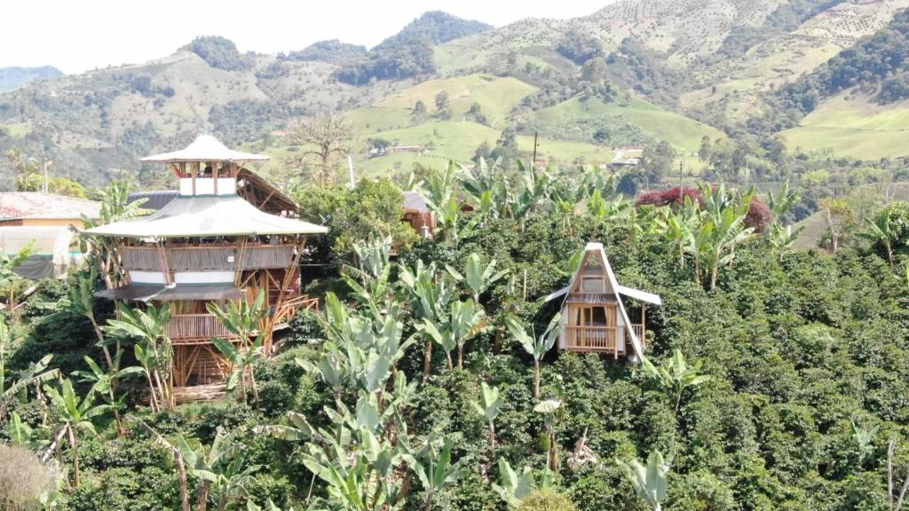 un grupo de casas en una colina con montañas en el fondo en El Turpial en Jericó