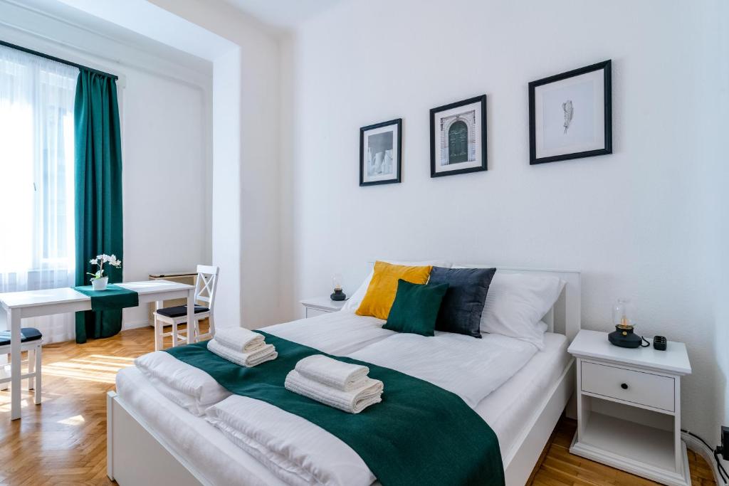 Un dormitorio blanco con una cama grande y una mesa en Budafoki Residence, en Budapest