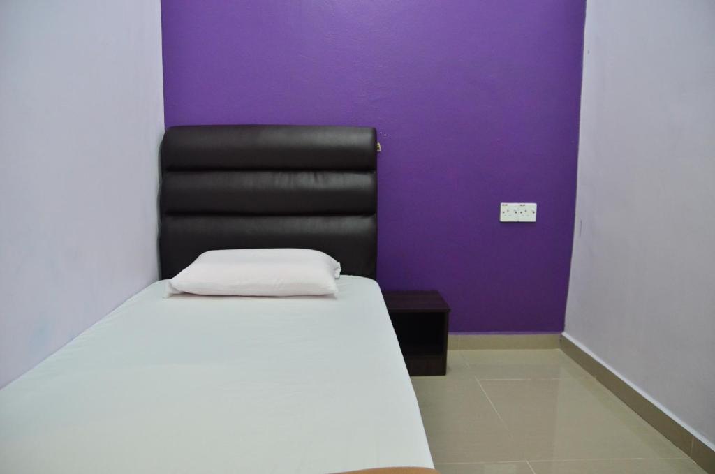 um quarto com uma cama e uma cadeira preta em Deena Hotel Bajet em Gua Musang