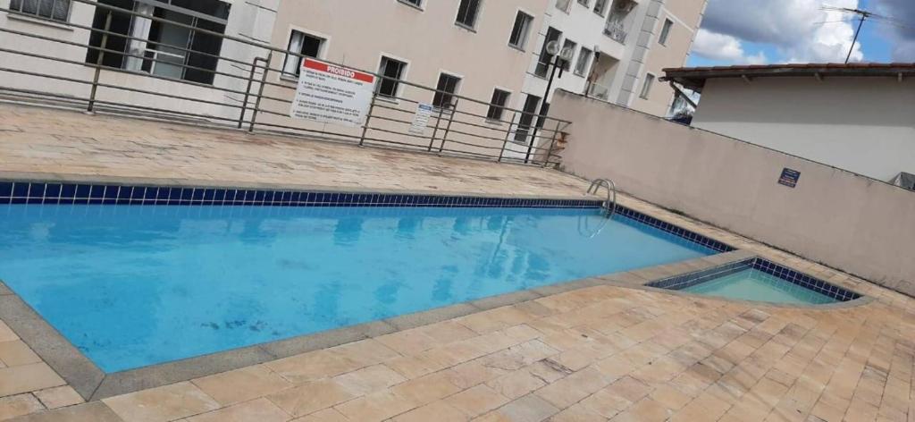 a swimming pool in front of a building at Apartamento Aconchegante in Goiânia