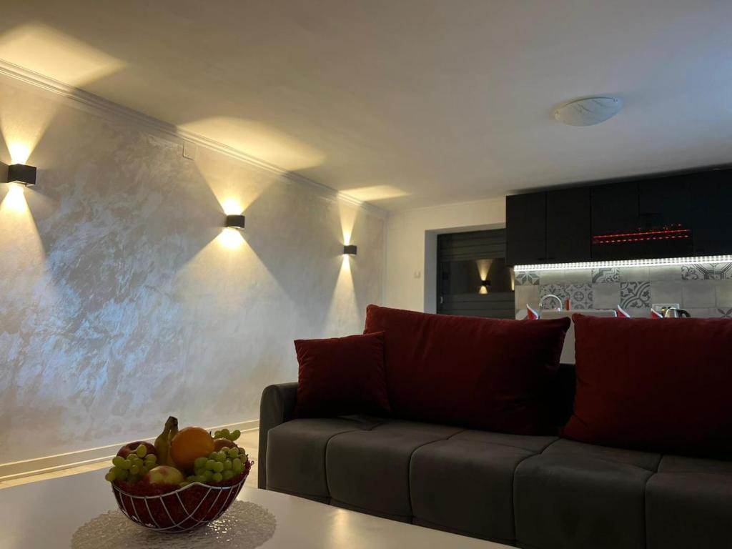 ein Wohnzimmer mit einem Sofa und einer Obstschale auf einem Tisch in der Unterkunft ViSTAMaRE Apartment in Opatija