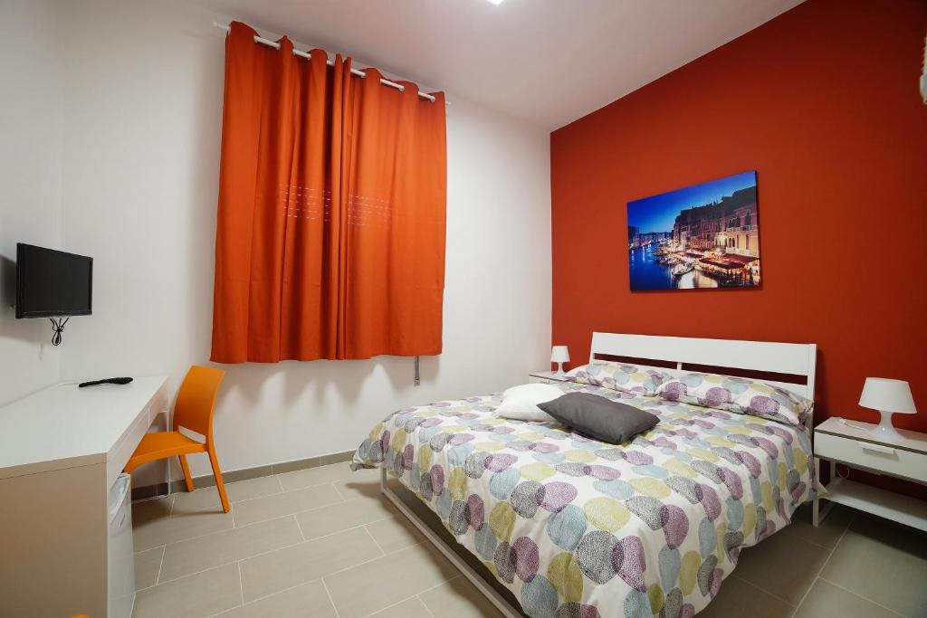 a bedroom with a bed and a desk and a monitor at Affittacamere Arcobaleno in Trapani