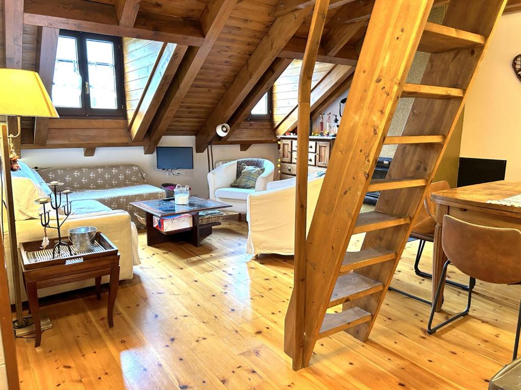 una sala de estar con una escalera en un loft en Apartament amb llar de foc i altell a Llavorsí by RURAL D'ÀNEU en Llavorsí