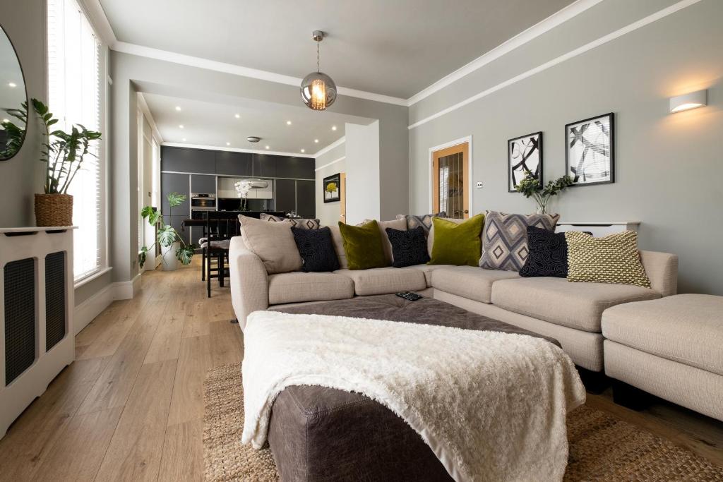 a living room with a couch and a table at Stylish Central Apartment with Parking & Lift in Bury Saint Edmunds