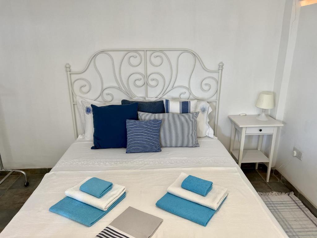 a bed with blue and white pillows on it at The Dive Studio in Larnaka