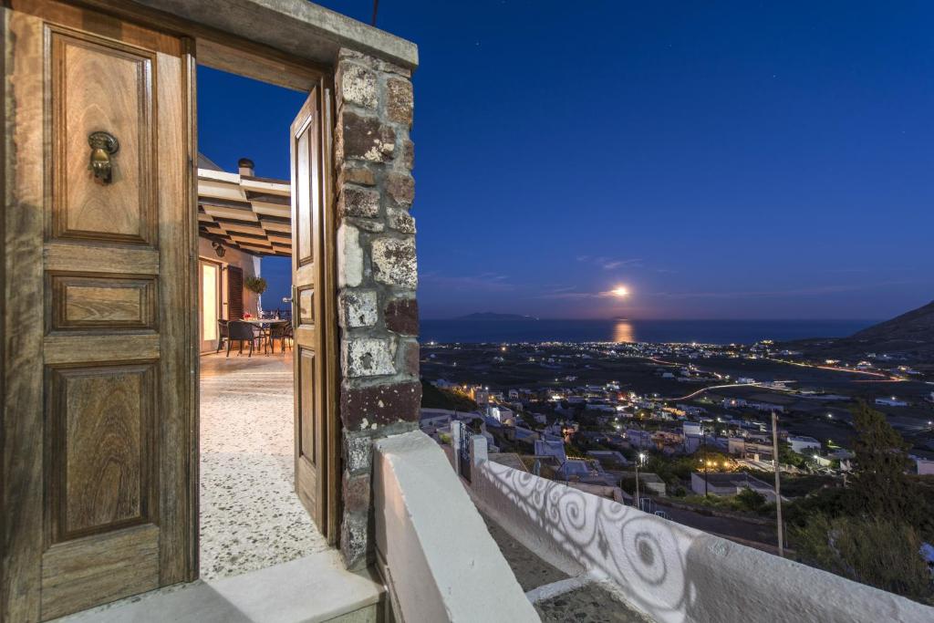 an open door with a view of a city at night at Morning Star Traditional Houses in Pyrgos