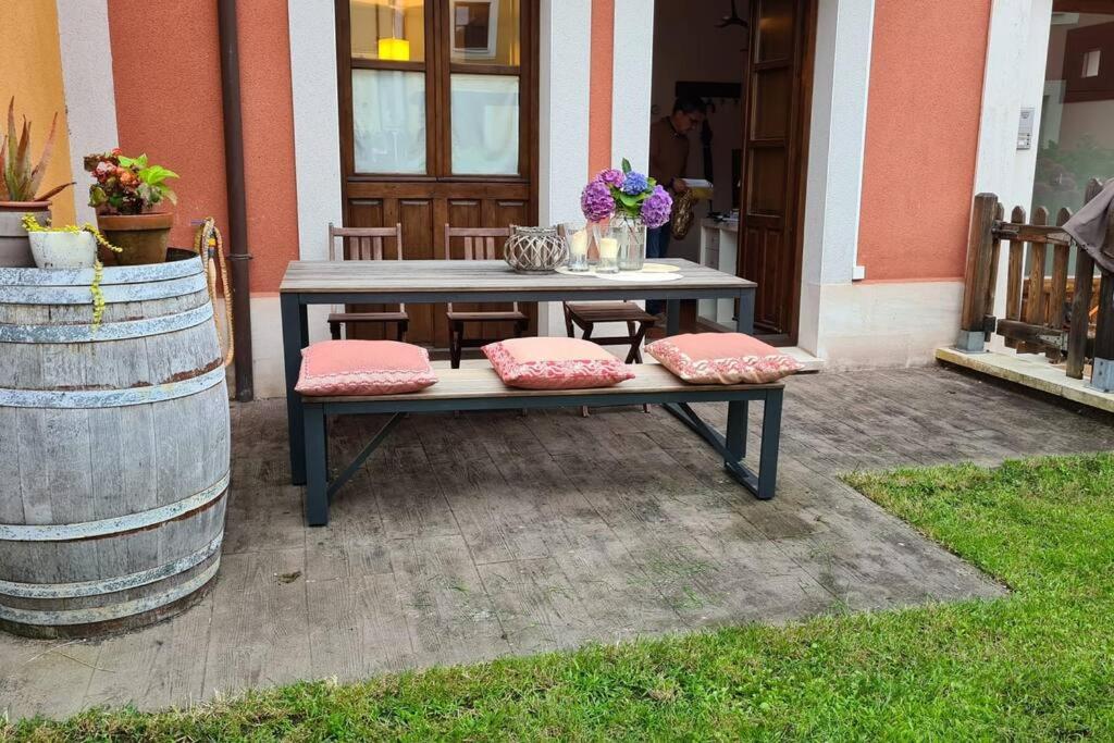 ein Picknicktisch mit Kissen auf einer Terrasse in der Unterkunft Preciosa casa con jardín en Nueva de Llanes in Nueva de Llanes