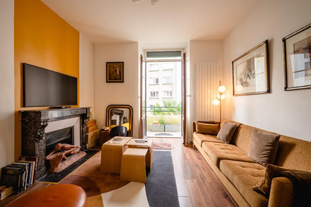 un salon avec un canapé et une cheminée dans l'établissement Le Cosy d'Aléry - Charming 3 room apartment near downtown, à Annecy