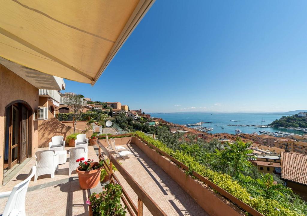 a balcony with chairs and a view of the ocean at Super Terrace in Porto Santo Stefano