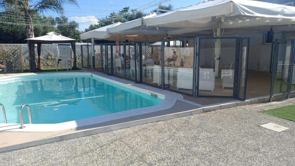 a swimming pool in a house with an umbrella at I Girasoli in Bari