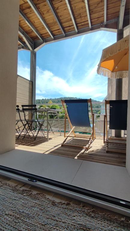 une terrasse avec une chaise et une télévision sur un patio dans l'établissement Terracotta - T2 avec Terrasse proche de Cassis, à Roquefort-la-Bédoule