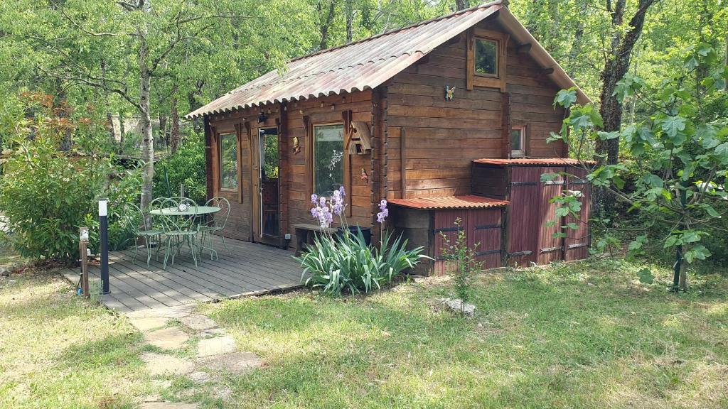Cabaña de madera pequeña con mesa en la cubierta en La cabane de Pioupiou en Fayence