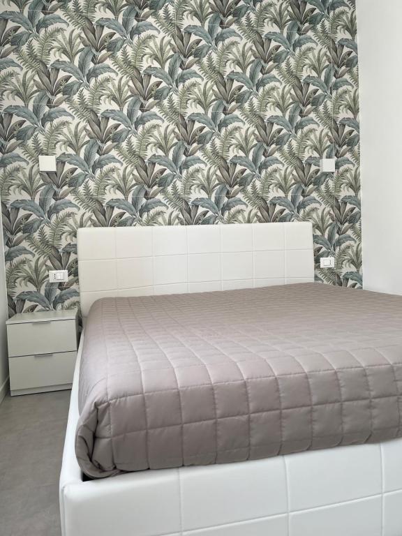 een slaapkamer met een bed en een muurschildering bij Profumo di Mare new 2023 in Alcamo Marina