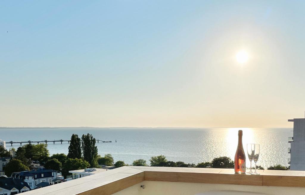 a view of the ocean from a balcony with a bottle and glasses at Ocean Dream in Międzyzdroje