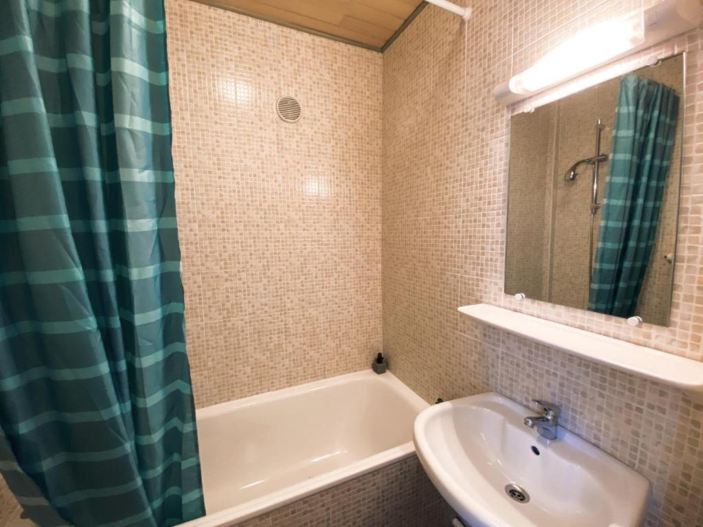a bathroom with a tub and a sink and a mirror at Hôtel Restaurant "La Petite Auberge" in Bourg-Saint-Maurice