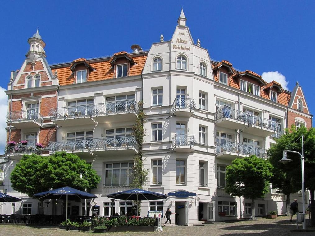 un gran edificio blanco con techo rojo en Große Ferienwohnung mit Dachterrasse am Marktplatz en Sassnitz