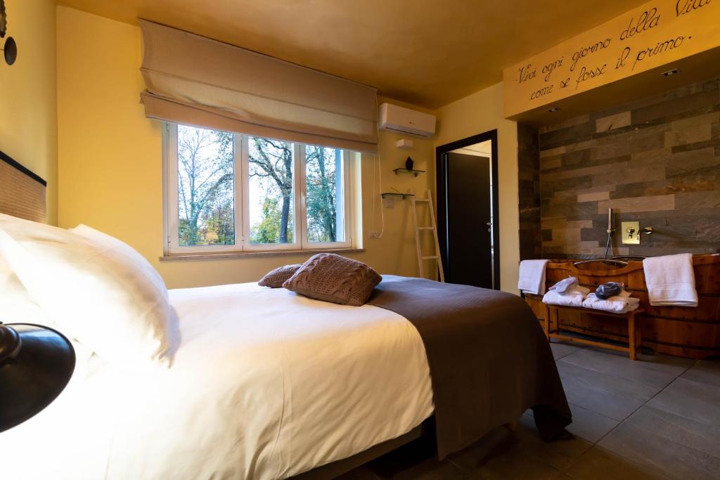 1 Schlafzimmer mit einem großen Bett und einem Badezimmer in der Unterkunft Oasi Degli Dei in Ranco