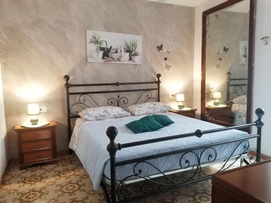 1 dormitorio con 1 cama grande y espejo en La casa di Cinzia en Pettorano sul Gizio