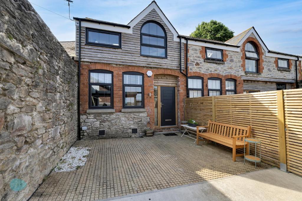 a brick house with a bench in front of it at 1 Bed - Bantham by Pureserviced in Plymouth