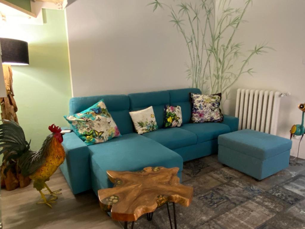 sala de estar con sofá azul y gallo en Appartamento nel cuore di Vigevano, en Vigevano
