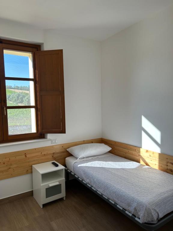 een slaapkamer met 2 bedden en een raam bij Agriturismo Poggio Ajano in Abbazia di Santa Maria in Selva