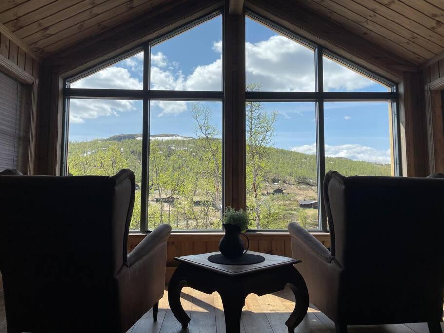 a room with two chairs and a table in front of a window at Hjemmekoselig hytte på Rauland in Rauland